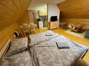 a large bed in a room with a kitchen at Apartmány SKI Čertovica in Vyšná Boca +10 photos