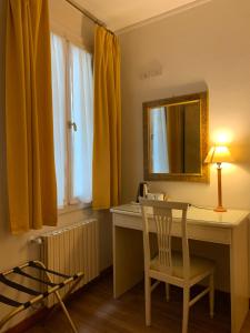 Zimmer mit einem Schreibtisch mit einem Spiegel und einem Stuhl in der Unterkunft AL CAMPANIEL BED AND BREAKFAST in Venedig