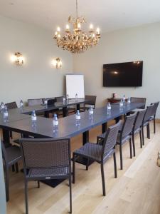 uma grande sala de conferências com uma grande mesa e cadeiras em Les Cabines em Houlgate