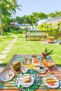 una mesa de picnic con platos de comida. en Pousada TeMoana en Ubatuba