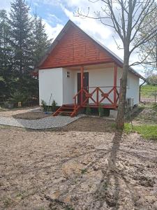 ein kleines weißes Haus mit rotem Dach in der Unterkunft AGROTURYSTYKA POD ŚNIEŻNĄ in Bystrzyca Kłodzka