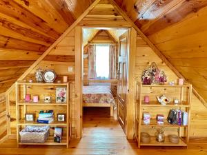 a bedroom in a log cabin with a bed at Dom Mazurski Klimat in Wiartel Mały