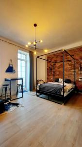 a bedroom with a bed and a brick wall at Bellevue apartments Vila Vlasta Starý Smokovec in Vysoke Tatry - Horny Smokovec