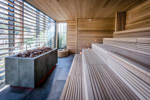 Großes Zimmer mit Holzwänden und Bänken in der Unterkunft Hotel Therme Meran - Terme Merano in Meran