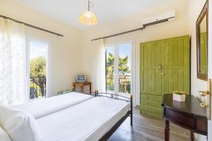 1 dormitorio con cama y ventana grande en Aloe Seaview Apartments by Konnect, 500m from Dassia Beach, en Dassia