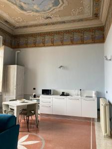 uma cozinha com armários brancos e uma mesa em ROSSO DI SERA em Castelfidardo