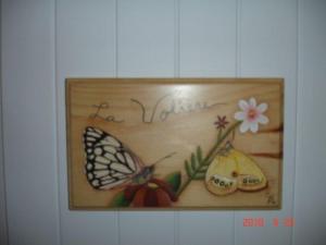 uma imagem de uma borboleta e fruta numa parede em La Petite Douceur em Lac Supérieur