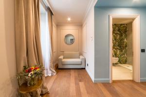 un pasillo con una silla y una mesa con flores en Palazzo 42 - Boutique Hotel & Suites, en Pistoia