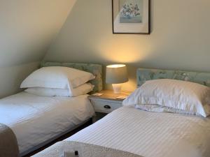 a bedroom with two beds and a lamp on a night stand at Glengair in North Berwick
