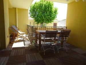 a table and chairs on a balcony with a tree at Les Manades in Aigues-Mortes