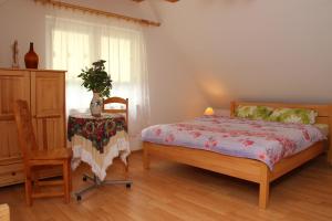 a bedroom with a bed and a chair and a table at Zamsówka in Guciów