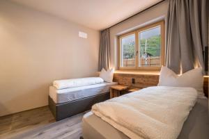 een hotelkamer met 2 bedden en een raam bij Seebrunn - Kaserfeld Alm in Ultimo