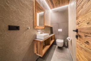 a bathroom with a sink and a toilet at Seebrunn - Kaserfeld Alm in Ultimo