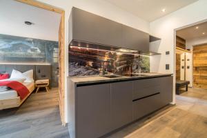 a kitchen with a fireplace in the middle of a bedroom at Seebrunn - Kaserfeld Alm in Ultimo