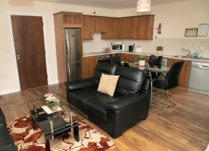a living room with a black leather couch and a table at Arch House B&B & Apartments in Athlone