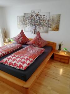 uma cama com almofadas vermelhas num quarto em Im Idyll 3 em Hengersberg