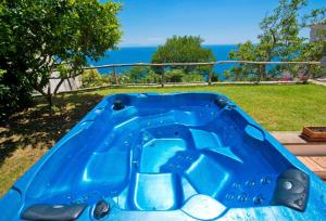 una piscina blu con l'oceano sullo sfondo di Sweet Home with outdoor unheated Whirlpool Tub a Praiano
