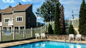 a fence with a pool in front of a house at Cathedral Ledge Resort in North Conway