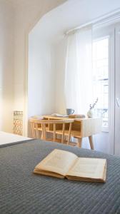 an open book on a bed with a table at 262 Baixa Guesthouse in Lisbon