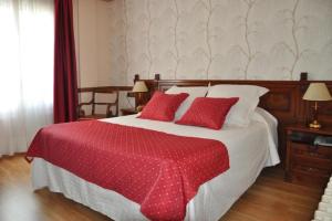 a bedroom with a large bed with red pillows at Hotel Edelweiss in Camprodon