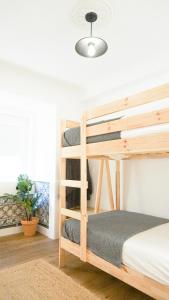 ein Schlafzimmer mit einem Etagenbett aus Holz und einer Topfpflanze in der Unterkunft 262 Baixa Guesthouse in Lissabon