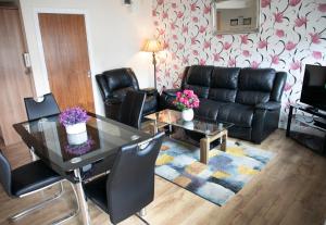 a living room with a table and a leather couch at Arch House B&B & Apartments in Athlone