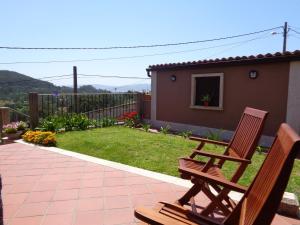 zwei Holzbänke auf einer Terrasse im Hof in der Unterkunft casa rústica Cabo Home in Cangas