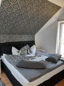 1 dormitorio con 1 cama grande y pared en Haus am Hang; Ferienwohnung Fernblick, en Stolberg