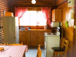 cocina con nevera, mesa y ventana en Eland Valley Resort en Underberg