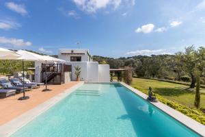 a villa with a swimming pool and a house at Can Skye in Sant Carles de Peralta