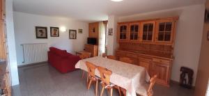 eine Küche mit einem Tisch und einem roten Sofa in der Unterkunft DOMUS ALPINA in Bormio
