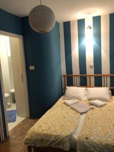 een slaapkamer met een bed en een blauwe muur bij Blue Bench Krk in Krk