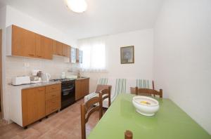 uma cozinha com uma mesa verde com uma tigela em Apartments Mira em Splitska