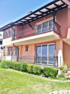a house with a balcony and a yard at Villa Stefan in Ohrid