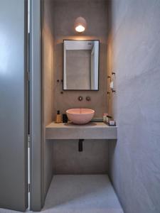 a bathroom with a bowl sink and a mirror at Karino Suite in Naousa
