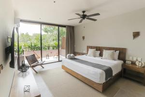 a bedroom with a large bed and a large window at Zereno Boutique Hotel in Tulum
