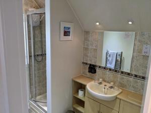 een badkamer met een wastafel en een douche bij Rockvilla Guest House in Lochcarron