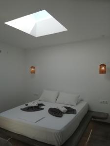 a bedroom with a white bed with a white ceiling at Studio farma in Zefiría
