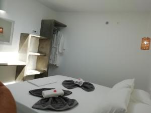 a white bed with two towels on top of it at Studio farma in Zefiría