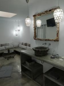 a bathroom with a sink and a mirror and a couch at Studio farma in Zefiría