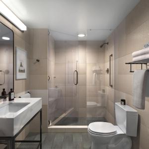 a bathroom with a sink, toilet, and bathtub at voco Times Square South, an IHG Hotel in New York