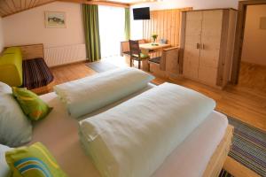 Zimmer mit 2 Betten, einem Tisch und einem Schreibtisch in der Unterkunft Gailerhof in Liesing