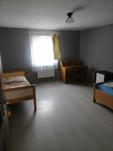 a room with two beds and a window and a desk at U Bronka w Książęcym Lesie in Niedaszów