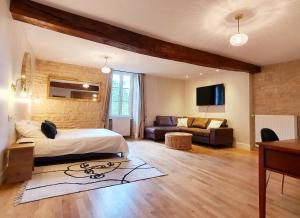 a bedroom with a bed and a living room at Le Moulin Neuf in Ancy-le-Franc