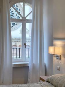 Dormitorio con ventana, cama y colcha en Residenza San Filippo, en Nocera Umbra