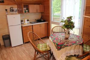 a kitchen with a table and chairs and a refrigerator at Zamsówka in Guciów +25 photos