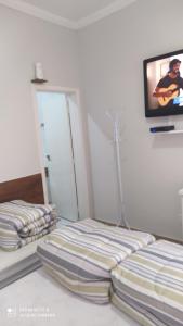 Rúm í herbergi á Pousada Quarto Familiar com ar,frigobar,wi fi, garagem +4 myndir