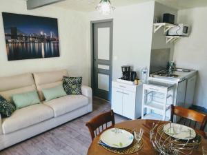 a living room with a couch and a table at Les Deux Riviéres in Les Touches-de-Périgny