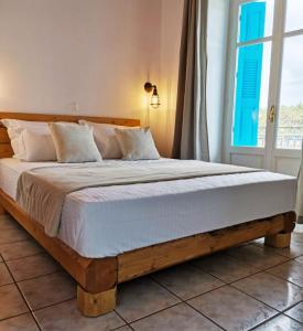a large bed in a bedroom with a window at Seamore Pension in Galaxidi