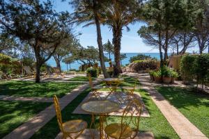 un patio con tavolo, sedie e vista sull'oceano di B&b Giglio di Mare a Cala Liberotto